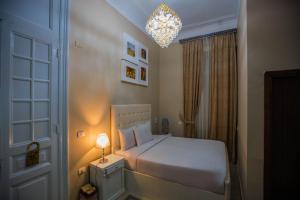 a bedroom with a white bed and a chandelier at The Square Boutique Hotel in Cairo