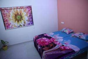 Una habitación con una cama con un cuadro de flores en la pared en Samyak bunglow, en Dwarka