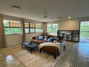 a living room with a couch and a table at Amongst the Trees in Mooloolah