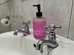 キラーニーにあるThe Killarney Grandのバスルームの洗面台の上に石鹸ボトルが置かれています。