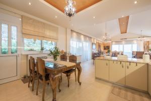 una cucina e una sala da pranzo con tavolo e sedie di Villa Amfiario - Luxury & Breathtaking views under the Attica Sun! a Kalamos