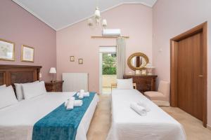 una camera da letto con due letti con asciugamani sopra di Villa Amfiario - Luxury & Breathtaking views under the Attica Sun! a Kalamos Altre 68 foto