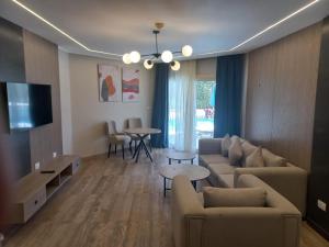 The V Luxury Resort Sahl Hasheesh في الغردقة: غرفة معيشة مع أريكة وتلفزيون