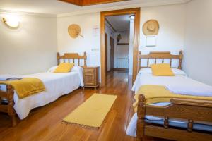 Duas camas num quarto com pisos em madeira em Casa Otxotenea em Lesaka