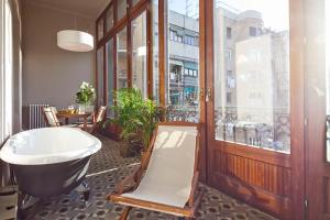 a bathroom with a bath tub and a table at Barcino Inversions - Apartments in Rambla de Catalunya in Barcelona