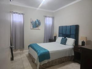 a bedroom with a large bed with a blue headboard at Cozy one bedroom at perkins in Kingston
