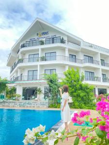 a little girl standing in front of a hotel at Khách sạn AQUARIUS GARDEN VÂN LONG NINH BÌNH in Ninh Binh