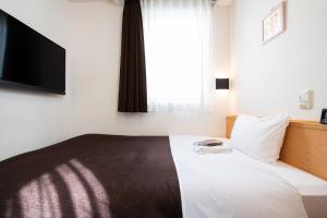 Postel nebo postele na pokoji v ubytování Ueno First City Hotel