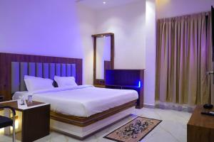um quarto com uma grande cama branca e um espelho em HOTEL SIGNATURE INN em Ambikāpur