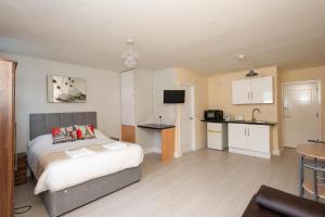 Cet appartement comprend une chambre avec un lit et une petite cuisine. dans l'établissement Saffron Studios, à Orpington