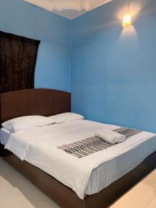 a bed in a room with a blue wall at Fiqthya Chalet & Cafe in Tioman Island +18 photos