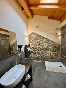 a bathroom with a sink and a stone wall at La Corte del Governo 565 in Lezzeno