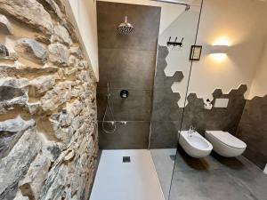 baño con pared de piedra y lavamanos en La Corte del Governo 565, en Lezzeno