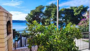 - une vue sur l'eau depuis une maison avec une brousse dans l'établissement Villa Penava, private beach, pool and 7min to Trogir, à Trogir