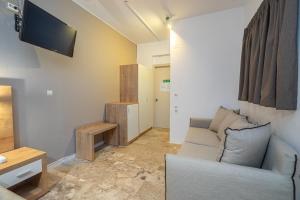 a living room with a couch and a tv at Karavados Beach Hotel in Karavádhos