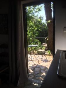 an open door to a patio with a table and a tree at Theisoa.Old Little house in the garden . Andritsaina. in Andritsaina