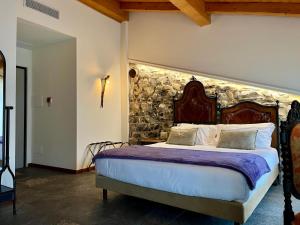 a bedroom with a bed with a stone wall at La Corte del Governo 565 in Lezzeno
