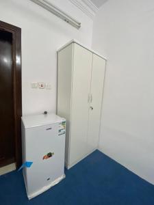 una nevera blanca y un armario en una habitación en نسائم العنبرية en Medina