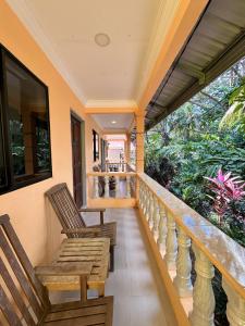 - un balcon avec deux chaises en bois sur une maison dans l'établissement Fiqthya Chalet & Cafe, à l'Île Tioman