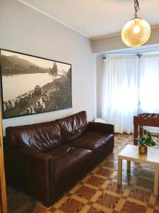 a living room with a leather couch and a painting at Segundo Antolín Yellow Door in Ponferrada