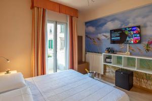 um quarto com uma cama e uma televisão na parede em Hotel Jane em Florença