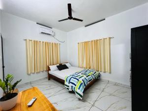 a bedroom with a bed and a ceiling fan at Riverrootsstays in Munroe Island +109 photos