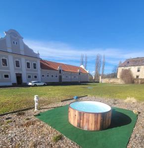 a wooden tub sitting on top of a putting green at Chateau Moravany - apartmány, teepee a wellness in Ronow an der Doubrava