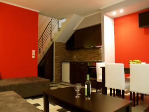 a living room with a table and a kitchen at Village Mare Residences in Kalyves Poligirou