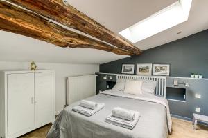 1 dormitorio con 1 cama con 2 toallas en La Demeure de Gab, en Trévoux