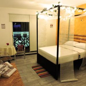 een slaapkamer met een bed in een kamer met een tafel bij HOTEL PH GIRARDOT in Girardot