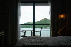 a room with a bed and a table and a window at Zuri Resort in Coron