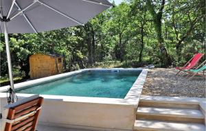 - une piscine avec un parasol, des chaises et une table dans l'établissement Les Jassines, à Lacoste