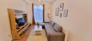 Una sala de estar con un sofá y un televisor. en Calea Moldovei Residence, en Bistriţa