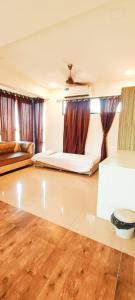 a living room with two beds and a wooden floor at New Phoenix By Glitz Hotels in Navi Mumbai