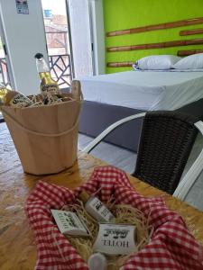 - une table avec un panier de pâtes et une bouteille de liqueur dans l'établissement HOTEL PH GIRARDOT, à Girardot