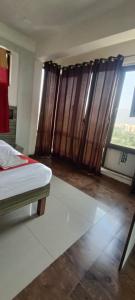 a bedroom with a bed and a window with curtains at New Phoenix By Glitz Hotels in Navi Mumbai