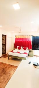 a bedroom with a large bed with a red headboard at New Phoenix By Glitz Hotels in Navi Mumbai