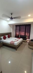 a bedroom with a bed and a ceiling fan at New Phoenix By Glitz Hotels in Navi Mumbai