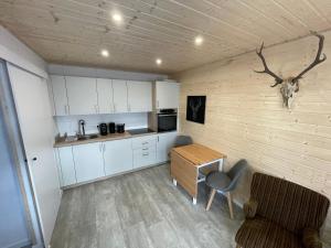 a kitchen with white cabinets and a table and a chair at TinyHaus #3 Hülben - Ortsrand - kostenlose Parkplätze in Hülben