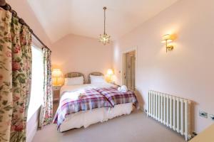 een slaapkamer met een bed en een raam bij Pass the Keys Garden Cottage · Beautiful cottage nestled in 80 acres of parkland in Diddlebury