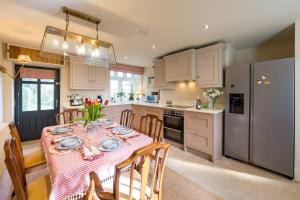 een keuken met een tafel met een roze tafelkleed bij Pass the Keys Garden Cottage · Beautiful cottage nestled in 80 acres of parkland in Diddlebury