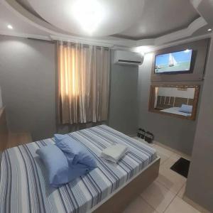 um quarto com uma cama e uma televisão na parede em Hotel Luar em São Paulo