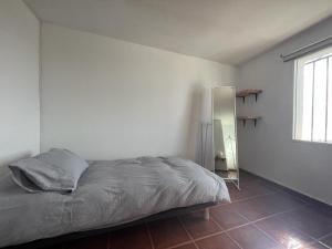 Schlafzimmer mit einem Bett und einem Wandspiegel in der Unterkunft ALMAFUERTE in Mijas