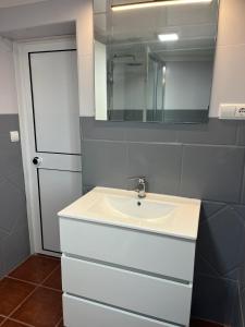 een badkamer met een witte wastafel en een spiegel bij ALMAFUERTE in Mijas