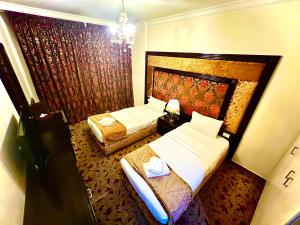 Cette chambre comprend 2 lits et une fenêtre. dans l'établissement Queens Suite Hotel, à Beyrouth