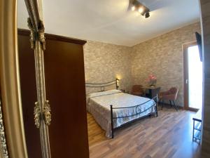 una camera con letto, tavolo e finestra di Uria Rooms & Suite B&B a Vieste