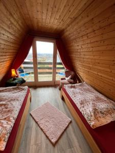 two beds in a room with a large window at Vennhütte in Monschau