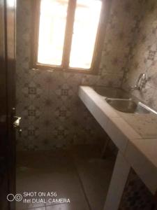 uma casa de banho com um lavatório e uma janela em Raski immobilier em Ouagadougou