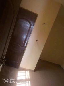 duże drewniane drzwi w rogu pokoju w obiekcie Raski immobilier w mieście Wagadugu