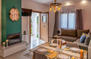 a living room with a couch and a table and a fireplace at Kostis Orange Resort in Volos